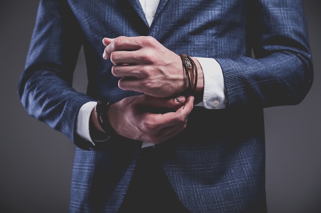 Free photo fashion portrait of young businessman handsome model man dressed in elegant blue suit on gray