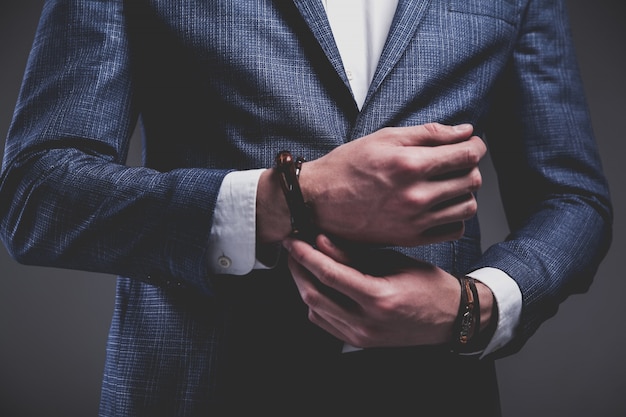 Fashion portrait of young businessman handsome model man dressed in elegant blue suit on gray