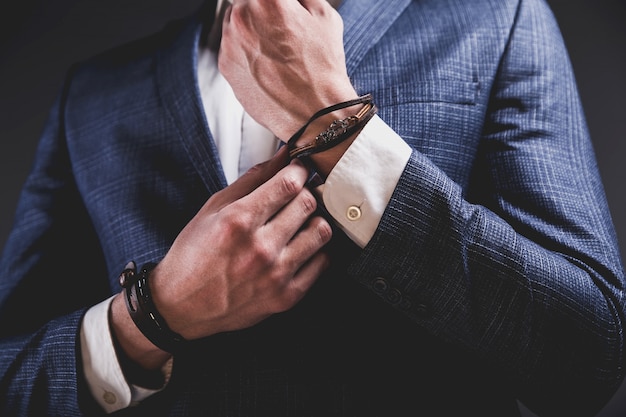 Fashion portrait of young businessman handsome model man dressed in elegant blue suit on gray