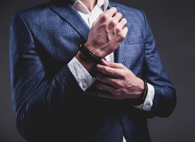 Fashion portrait of young businessman handsome model man dressed in elegant blue suit on gray