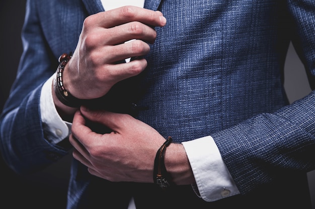 Fashion portrait of young businessman handsome model man dressed in elegant blue suit on gray