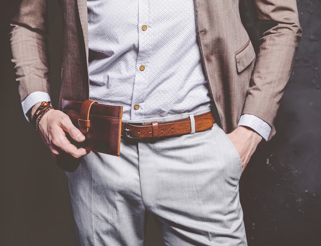 Fashion portrait of young businessman handsome model man dressed in elegant brown suit with accessories