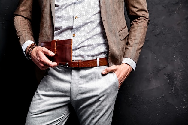 Free photo fashion portrait of young businessman handsome model man dressed in elegant brown suit with accessories