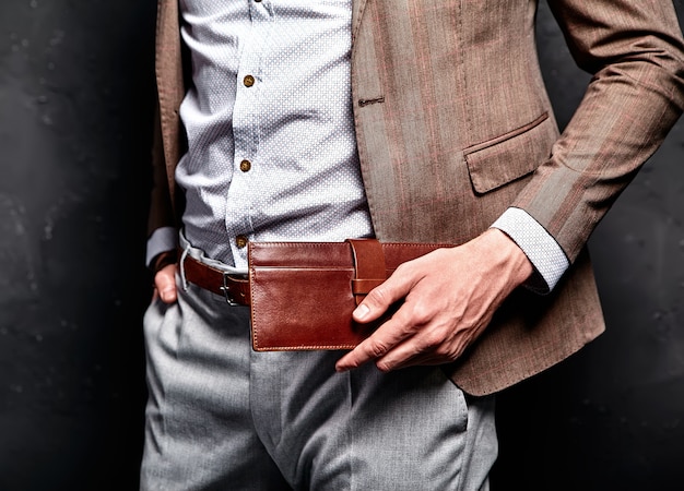 Fashion portrait of young businessman handsome model man dressed in elegant brown suit with accessories