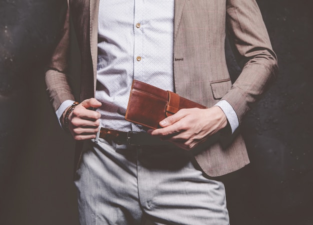 Free photo fashion portrait of young businessman handsome model man dressed in elegant brown suit with accessories