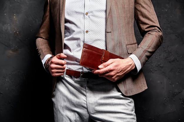 Free photo fashion portrait of young businessman handsome model man dressed in elegant brown suit with accessories