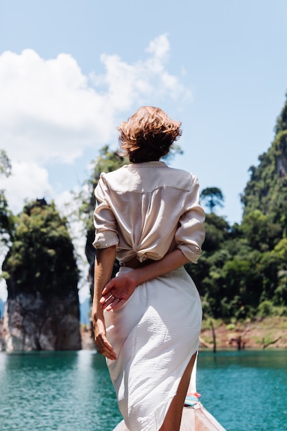 Fashion portrait of young woman on vacation, on asian wooden boat