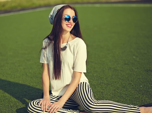 Free Photo fashion stylish beautiful young brunette woman model in summer hipster casual clothes posing on street background in the park