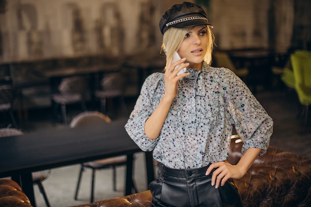 Free photo fashion woman in a cafe talking on the phone