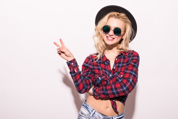 Fashion woman girl in black sunglasses and black hat isolated on pink