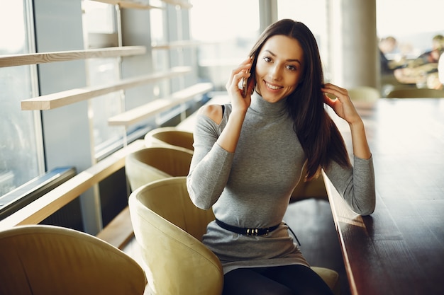 Free photo fashion young girl sitting in a cafe