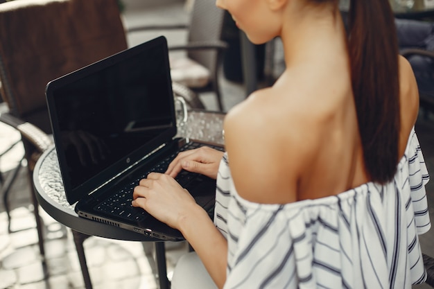 Fashion young girl sitting in a summer cafe