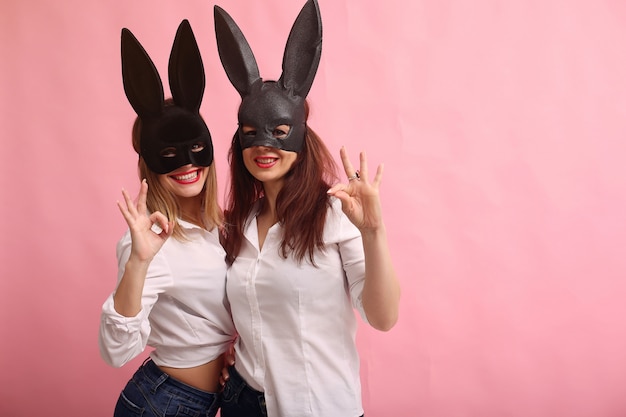 Free photo fashion young women posing with black rabbit mask