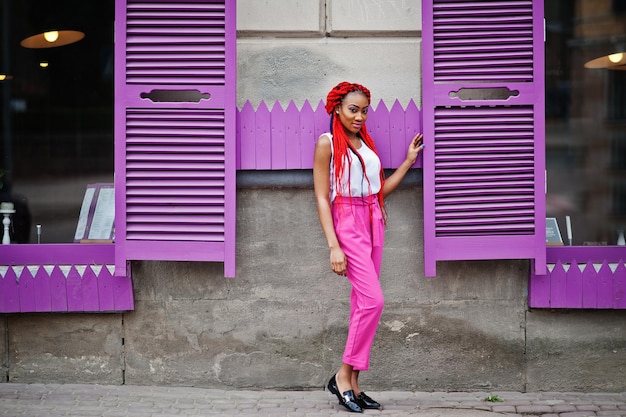 Free photo fashionable african american girl at pink pants and red dreads posed outdoor