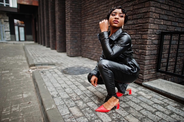 Free Photo fashionable beautiful african american woman posing in black leather jacket and pants at street