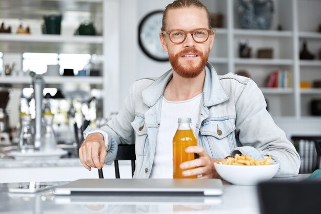 Fashionable hipster guy dressed in denim shirt and wearing stylish glasses