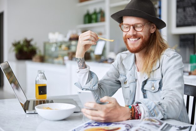 Fashionable hipster guy dressed in stylish black hat and denim shirt