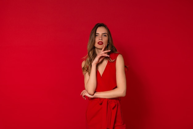 Fashionable lovely woman in red dress posing