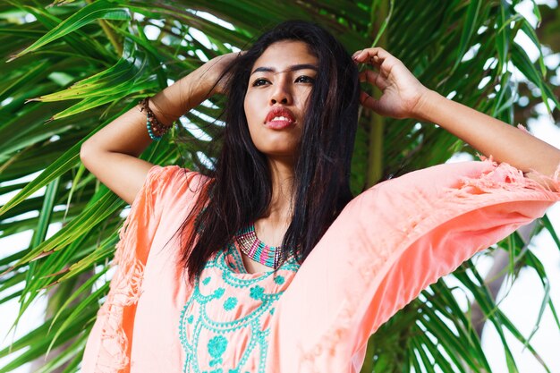 Fashionable portrait of asian woman posing on the tropical beach