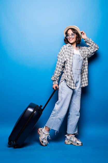 Fashionable woman running with suitcase