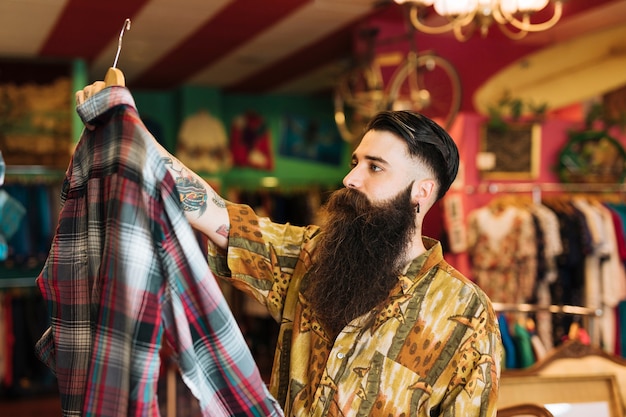 Fashionable young man shopping for clothes at store