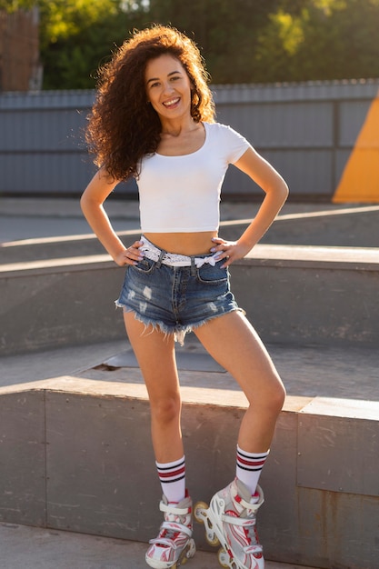 Fashionable young woman posing outdoors in rollerblades