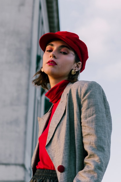 Free photo fashionable young woman with red cap looking at camera