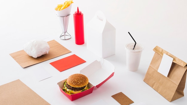 Free Photo fast food; disposal cup; sauce bottle and parcel on white background