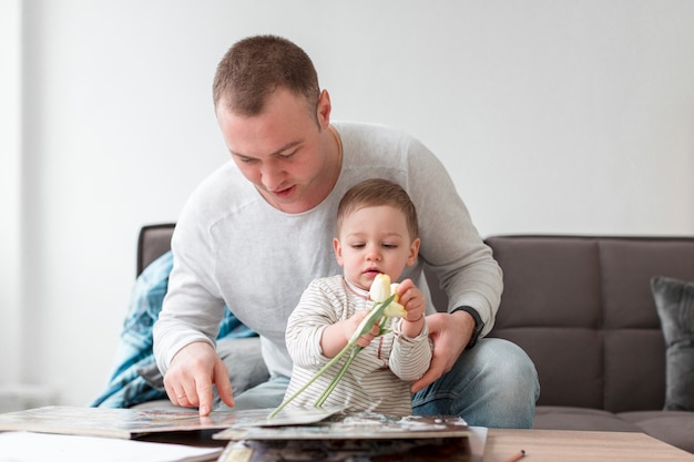 Father and baby with book and flower