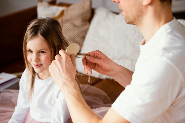 Father brushing his daughter's hair