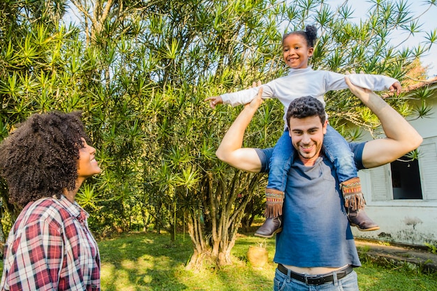 Free photo father carrying daughter on shoulders