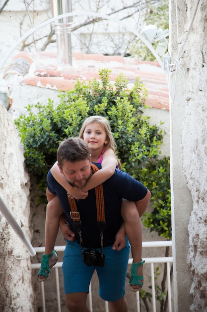 Free photo father carrying his daughter on his back