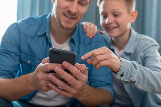 Father and cute son playing on the telephone