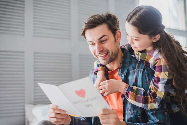 Father and daughter looking at hand drawn card on fathers day