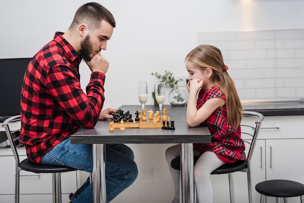 Free Photo father and daughter playing chess on fathers day