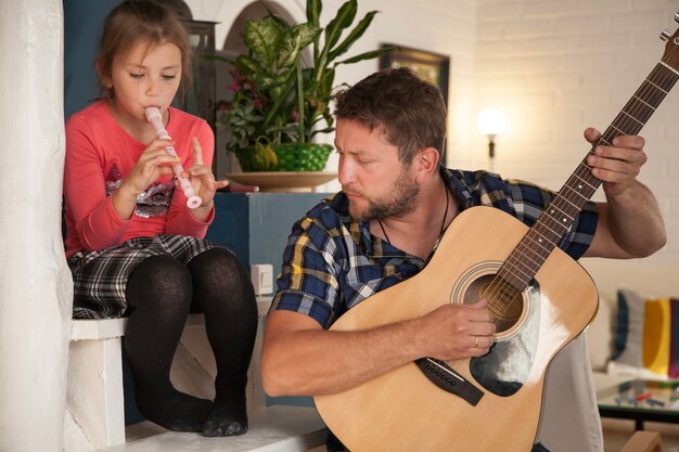 Father and daughter playing musical instruments