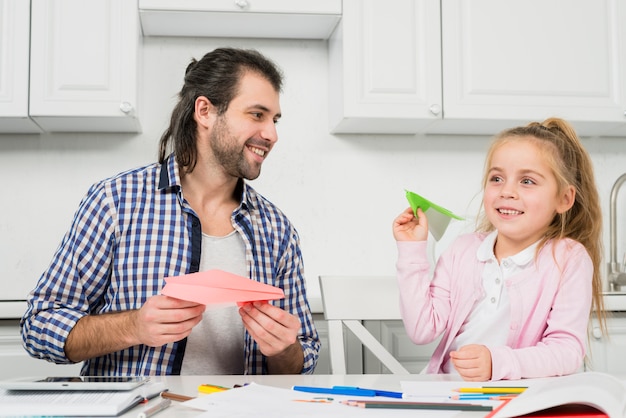 Father and daughter playing with planes