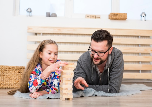 Free photo father and daughter playing with wood blocks