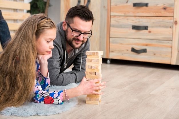 Free photo father and daughter playing with wood blocks