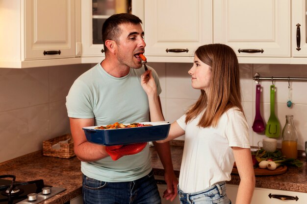 Father and daughter preparing food in the kitchen