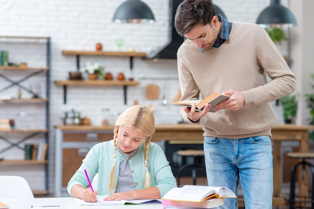 Free photo father and daughter studying in the kitchen