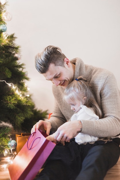 Free photo father and daughter with bag at christmas