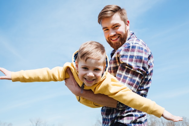 Father and his little son playing together in a park