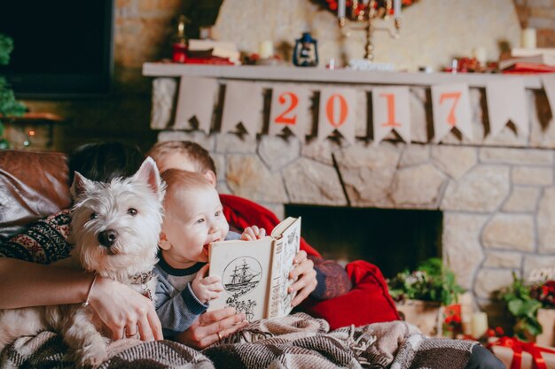 Father holding a book that your baby is looking at and touching