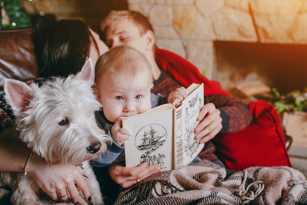 Father holding a book where the baby is leaning