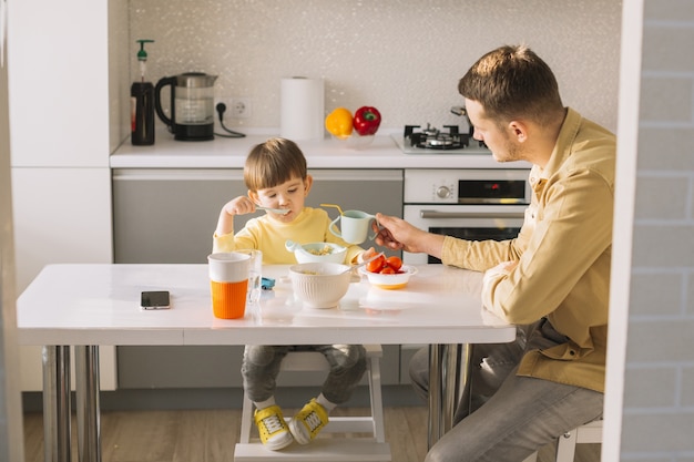 Father holding the cup for his son to drink