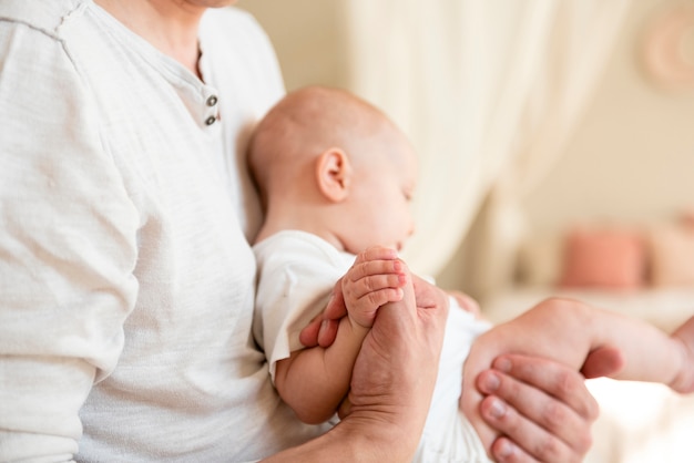 Father holding hands with newborn