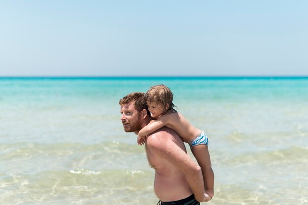 Father holding son at the beach