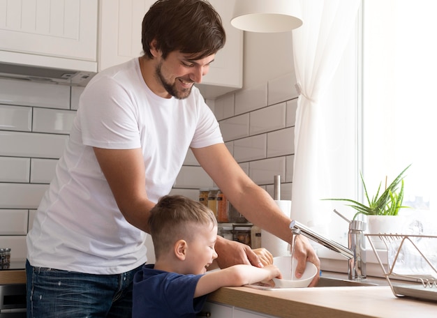 Father and kid washing dish