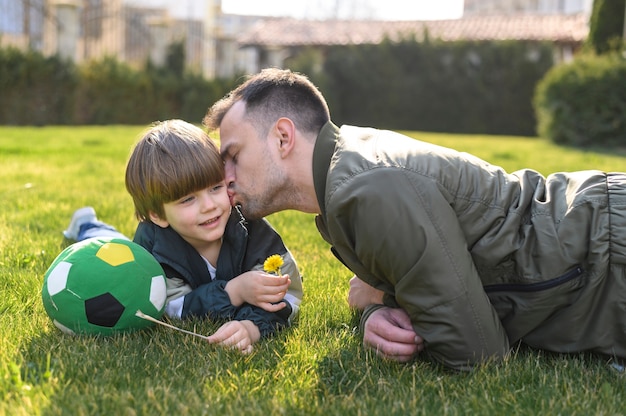 Father kissing son outside